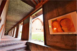 壁面にはアートが飾られている開放的な煉瓦敷きの通路