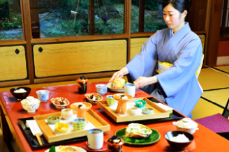 仲居さんが手際よく一品一品テーブルに並べられる和の朝食風景。